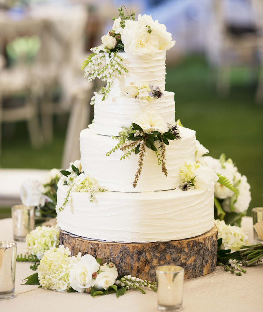 White wedding cake on rustic wood slab