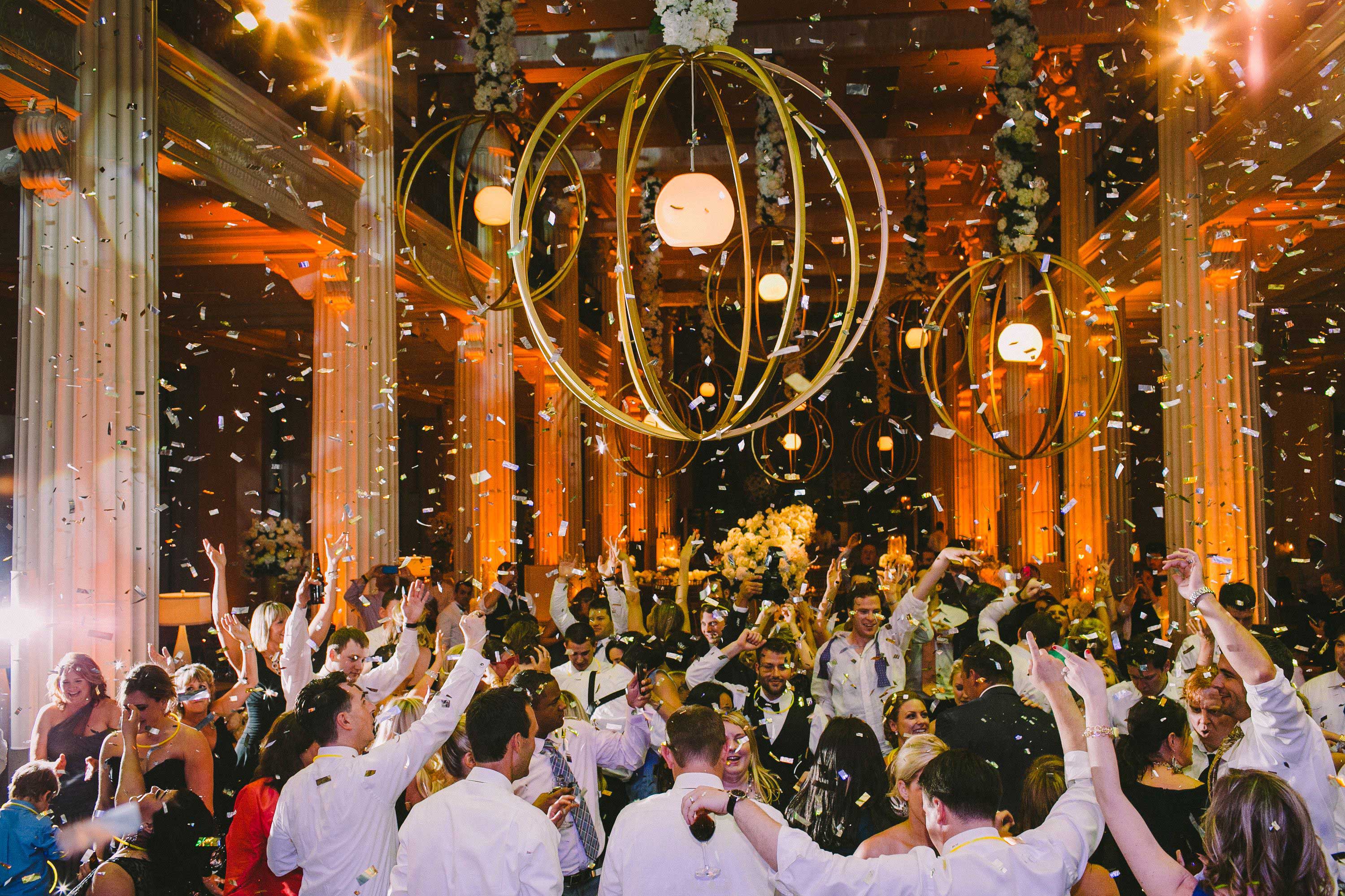  Mariée et marié avec des invités sur une piste de danse en confettis 