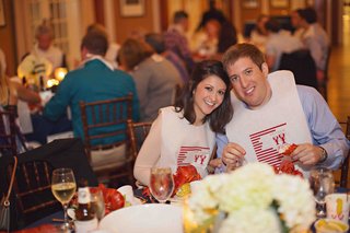 Lobster Bake Couple bride-and-groom-with-lobster-bibs-at-rehearsal-dinner