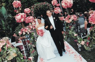 Pink & White Garden Ceremony couple-walks-up-aisle-surrounded-by-pink-flowers