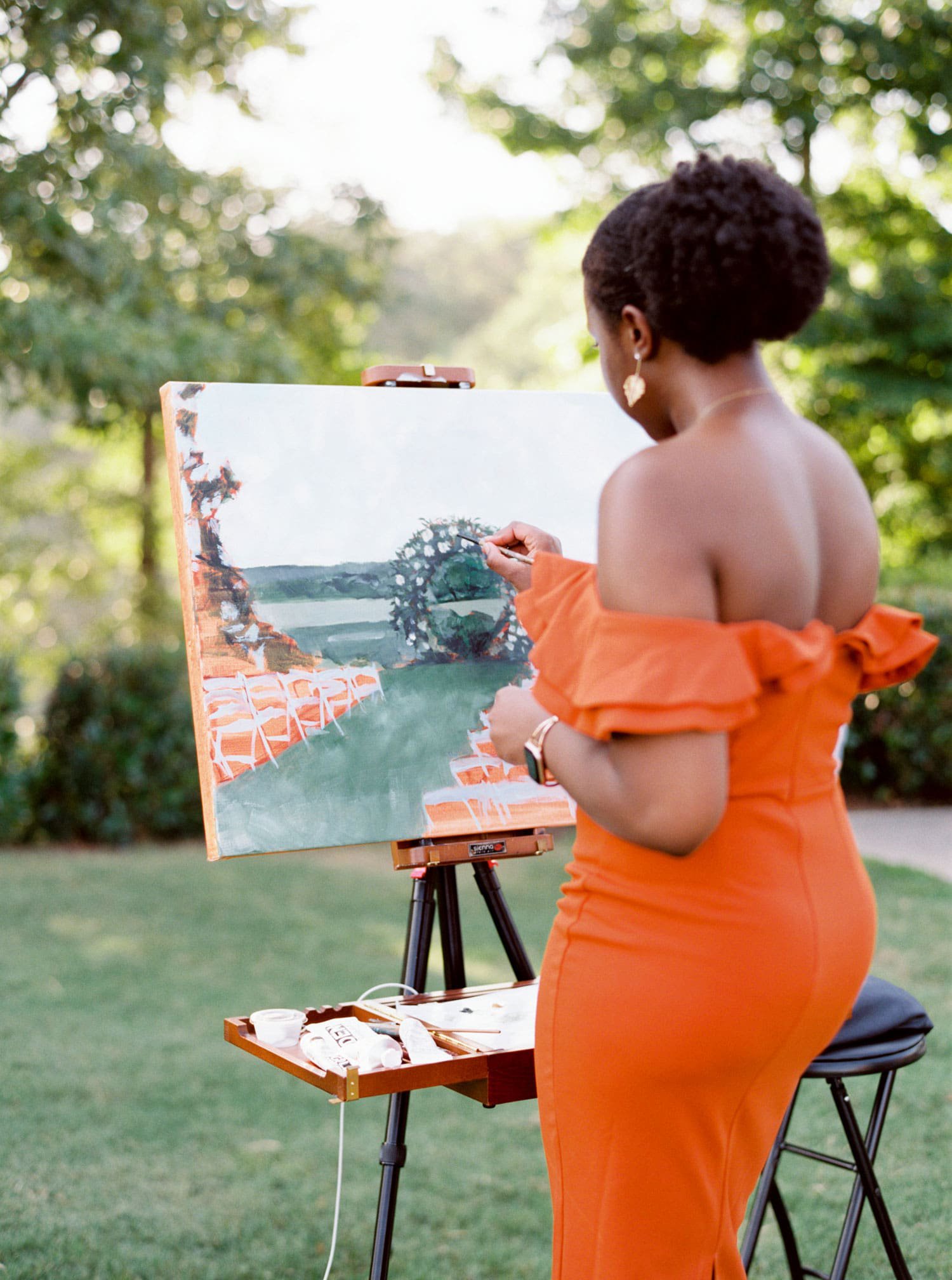 wedding live event painter in orange dress