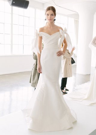 Off-the-Shoulder Trumpet Gown by Marchesa Bridal marchesa-bridal-spring-summer-2018-sleek-trumpet-gown-off-the-shoulder-sleeves-bows-wrap-bodice