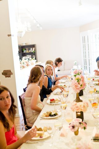 Dining Bridal Shower Guests guests-sit-at-long-table-to-eat