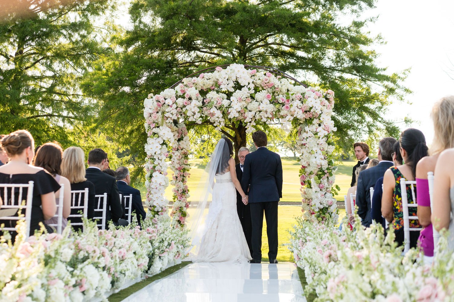 Bride & Groom with Officiant Under Arch