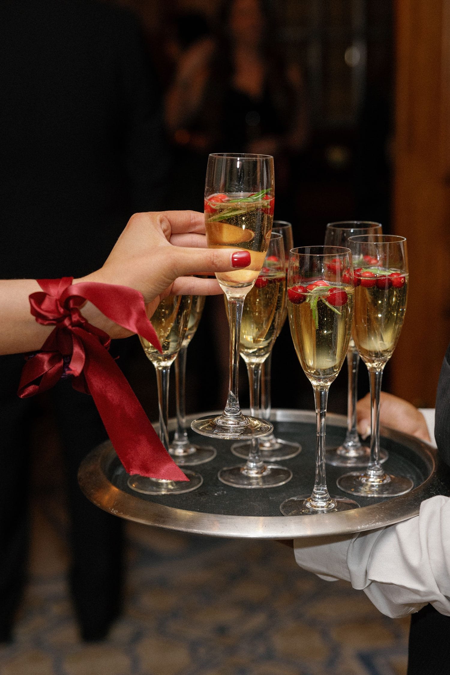 holiday wedding ideas champagne flute with cranberries and herbs tray passed