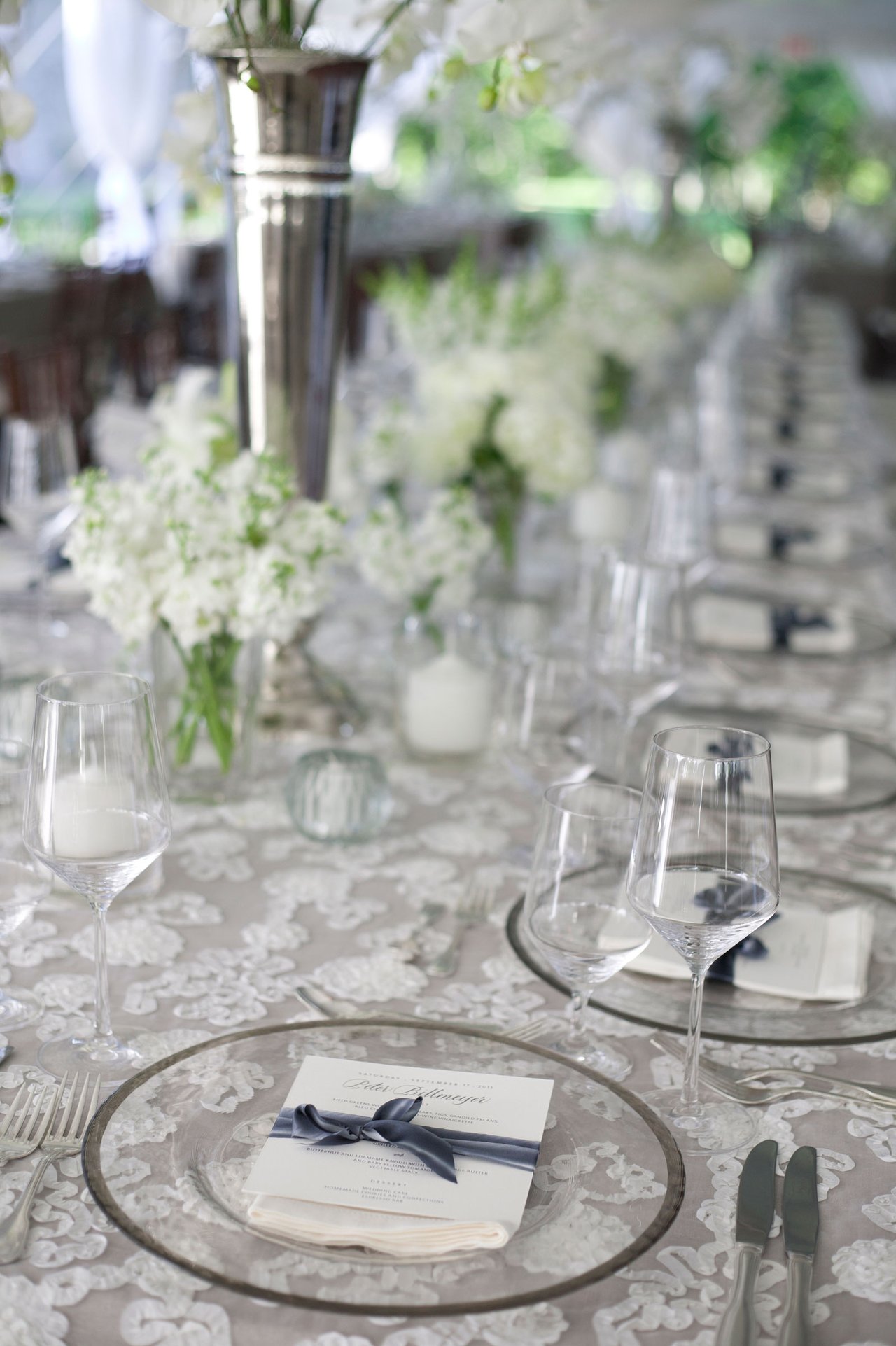 Long Table with White Lace Linens and Glass Plates with Place Cards