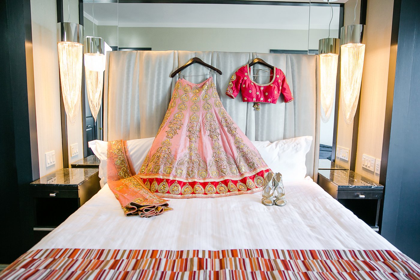 Traditional Indian Bridal Outfit Hanging Over Bed